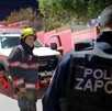 Elemento de Protección Civil frente a un oficial de la Policía de Zapopan visto de espaldas con un camión de bomberos en el fondo