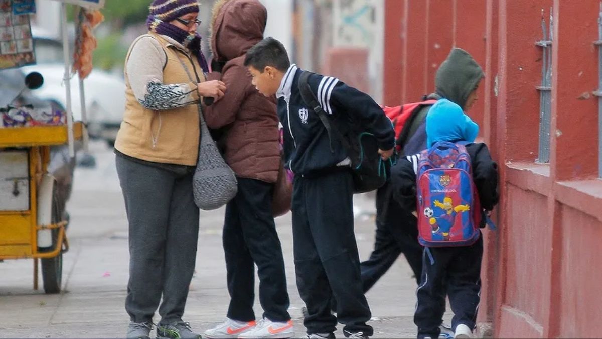 Niños abrigados a las afueras de una escuela en Torreón