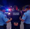 Policía de Guadalajara siendo arrestado por dos policía de Tlajomulco en medio de la calle con patrullas y personas alrededor
