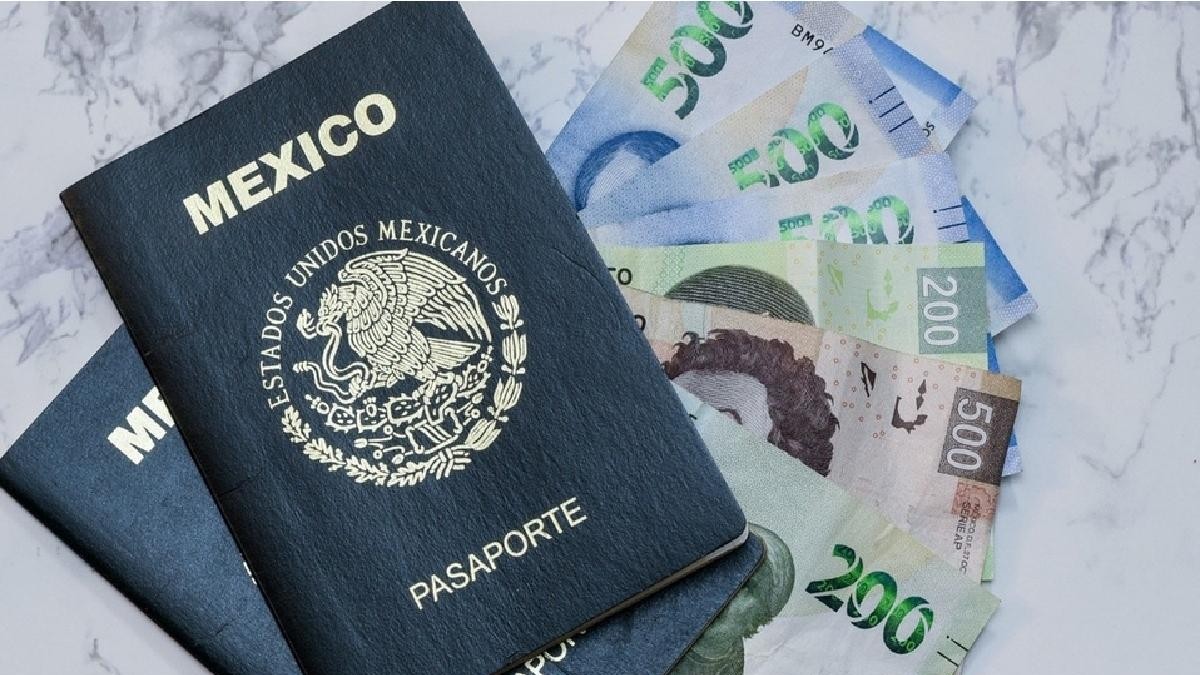 Dos pasaportes mexicanos uno encima del otro sobre varios billetes de 500 pesos sobre una mesa blanca