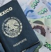 Dos pasaportes mexicanos uno encima del otro sobre varios billetes de 500 pesos sobre una mesa blanca