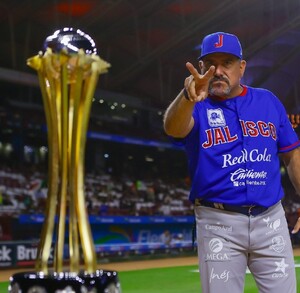 El mánager Benjamín Gil hace una señal de victoria con los dedos frente al trofeo de campeones de la LMP, tras el triunfo de los Charros de Jalisco.
