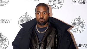 Kanye West posando serio para la cámara, portando vestimenta completamente negra.