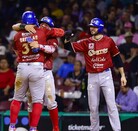 En un partido nocturno, un jugador de los Charros de Jalisco se desliza de cabeza en una base mientras el defensivo rival intenta hacer el out.