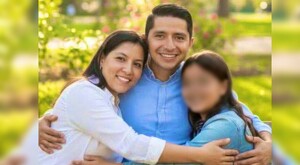 Integrantes de una familia abrazados con la madre a la izquierda, el padre en medio y su hija a la derecha con un jardín desenfocado de fondo