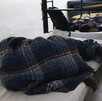 Hombre acostado en cama en refugio en Monterrey.