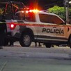 Oficiales y patrulla de la Policía de Tlaquepaque con la sirena encendida detrás de una cinta policiaca amarilla en medio de una calle