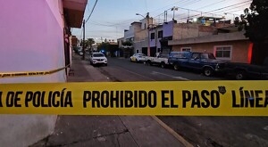 Cinta policiaca amarilla acordonando una calle en Guadalajara con automóviles y casas alrededor
