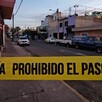 Cinta policiaca amarilla acordonando una calle en Guadalajara con automóviles y casas alrededor