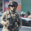 Militar armado aguarda durante un cateo realizado a la calle 46 Poniente en Puebla capital.