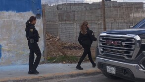 Se observan a dos mujeres portando uniformes de policías, caminando sobre una banqueta.