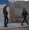 Se observan a dos mujeres portando uniformes de policías, caminando sobre una banqueta.