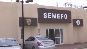 Se observa un edificio color café con letras que dicen Semefo.