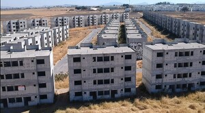 Edificios de viviendas en obra negra abandonados en un fraccionamiento de Tlajomulco con maleza creciendo alrededor