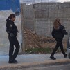 Se observan a dos mujeres portando uniformes de policías, caminando sobre una banqueta.