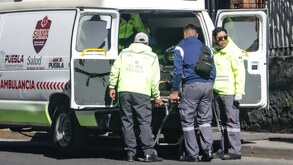 Personal de emergencia atendiendo a una mujer afuera de una ambulancia en Puebla.