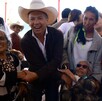 Pablo Lemus, con sombrero de charro, sonríe y estrecha la mano de una mujer adulta mayor durante un evento público rodeado de varios ciudadanos.