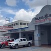 Se observa una fachada color gris con letras que dicen Policía Municipal y hay varios vehículos estacionados.
