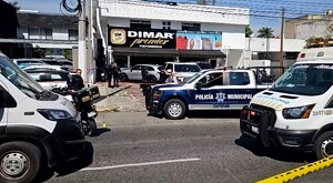 Patrullas de la Policía Municipal de Zapopan junto con ambulancias estacionadas a las afueras de un comercio