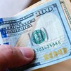 Dólar estadounidense siendo agarrado por una persona.
