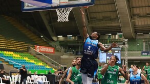 Un jugador de los Astros de Jalisco salta hacia la canasta para un enceste durante un partido contra los Caimanes en un estadio lleno de gente.
