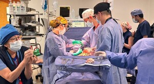 Médicos, enfermeras y asistentes realizando una cirugía de donación de órganos con equipo médico dentro de un quirófano