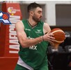 Un jugador de básquetbol con uniforme verde sostiene el balón con ambas manos, mientras al fondo aparece el logotipo del equipo Astros de Jalisco.