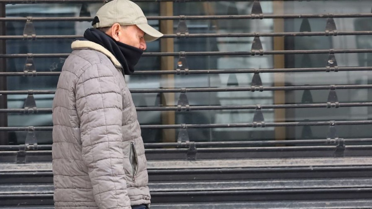 Persona con frío caminando en la calle.