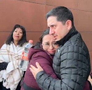 Se ven varias personas, entre ellas un hombre y una mujer que están abrazados.