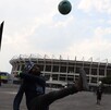 Hombre jugando fútbol frente al Estadio Azteca previo al Mundial 2026.