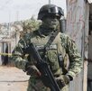 Una persona con vestimenta militar y un arma resguarda la zona de un crimen en Puebla.