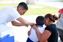 Enfermero vacunando a menor de la influenza en Nuevo León.