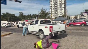 Momento en que una camioneta pick up blanca arrolla a manifestantes durante una protesta por el caso Clarisa Rodríguez, hecho captado en video.