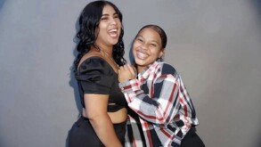 DOS MUJERES POSANDO A LA CÁMARA VESTIDAS CON PANTALÓN DE NEGRO Y VESTIDO NEGRO