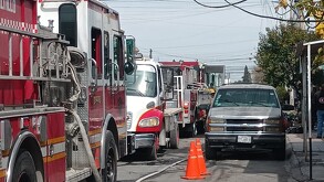 Se observa un camión de bomberos y a lado varias casas.