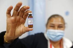 Personal de salud sujetando vacuna contra el sarampión.