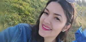 Clarisa Rodríguez viendo de medio perfil a la cámara mientras sonríe con unos lentes de sol en la cabeza y de fondo áreas verdes