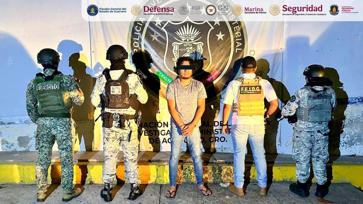 un hombre detenido custodiado por elementos del ejército y policía estatal