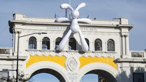 Escultura de un conejo blanco gigante apoyado sobre Los Arcos de Guadalajara en un día soleado