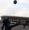Hombre jugando fútbol frente al Estadio Azteca previo al Mundial 2026.