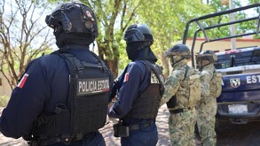 Dos oficiales de la Policía Estatal de Colima junto s dos militares de la marina al lado de una patrulla del estado
