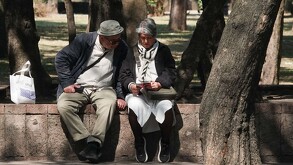 Pareja de adultos mayores en una banca al aire libre en la Ciudad de México.