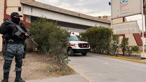 Se ve a un policía con uniforme y una pistola afuera de un Motel que se llama Motel Plaza Saltillo.
