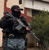 Se ve a un policía con uniforme y una pistola afuera de un Motel que se llama Motel Plaza Saltillo.