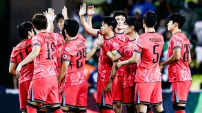 Jugadores de la Selección de Corea del Sur saludándose dentro de una cancha de futbol.