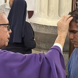 Sacerdote poniendo ceniza a una persona en la catedral