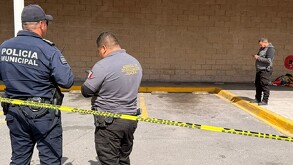 Se observa a dos policías y una cinta amarilla de precaución, atrás una cobija en el suelo.