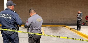 Se observa a dos policías y una cinta amarilla de precaución, atrás una cobija en el suelo.