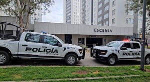 Dos patrullas de la Policía Municipal de Tlaquepaque estacionadas al exterior de unas torres de departamentos en el complejo Escenia Residencial