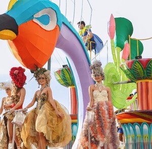 Hombres y mujeres arriba de un carro alegórico con la figura de un ave colorida en el Carnaval de Mazatlán